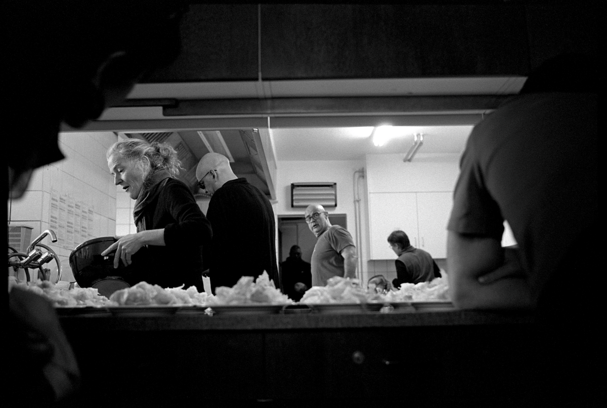 Schwarz-weiss Fotografie von Menschen in einer Gastronomie-Küche